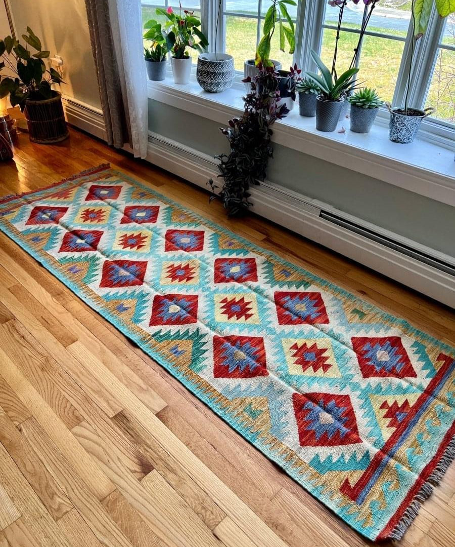 Kilim runner rug with geometric diamond motifs in turquoise, red, blue, and cream