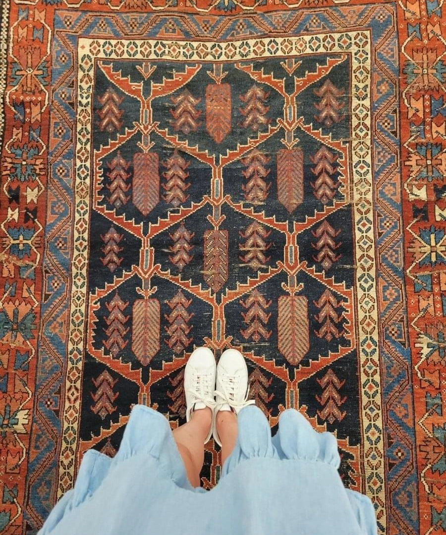 Antique Persian Afshar rug with navy center medallion, rust and teal details, wide border