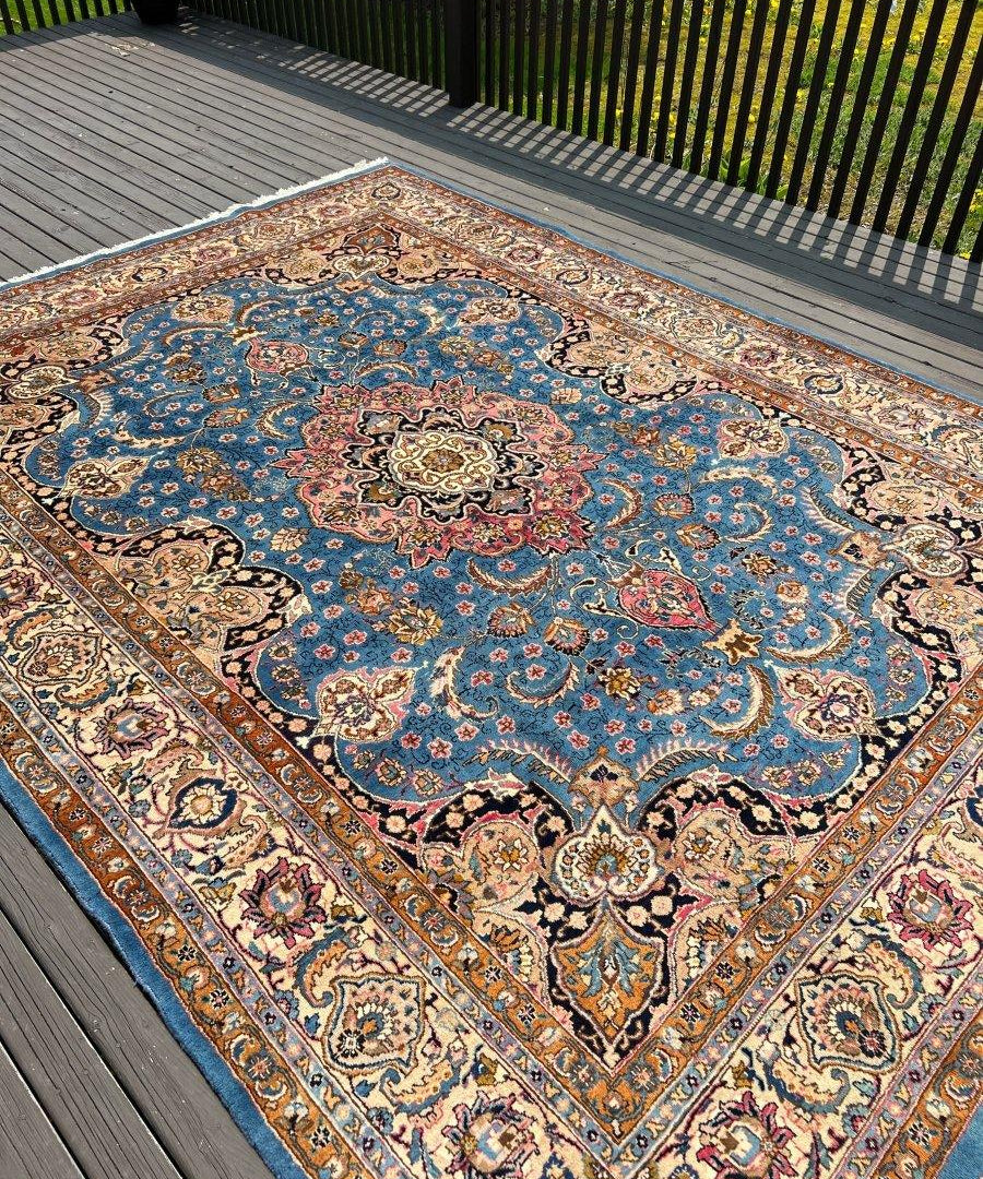 Persian Kashmar rug on deck boards, blue central medallion with multicolor corner ornaments