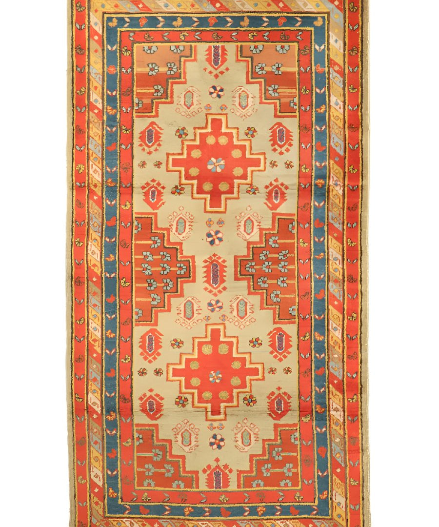 Rectangular rug with red and teal geometric pattern, cream center medallions, and border trim