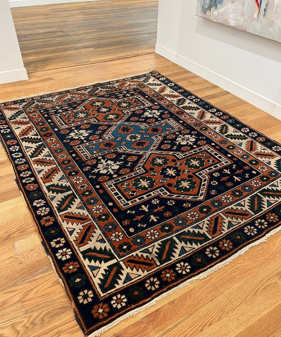Geometric Central Anatolian rug in navy with orange-brown border and teal motifs on floor