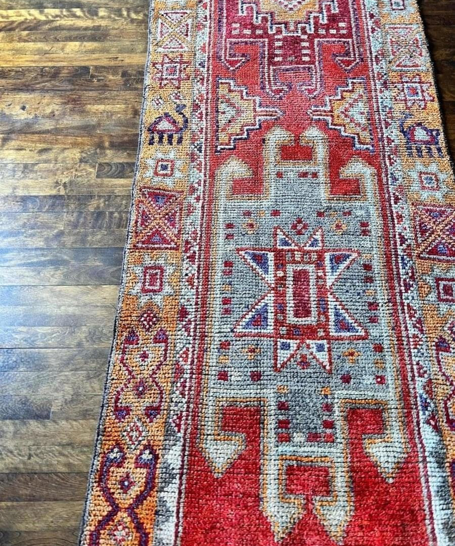 Blue and red tribal runner rug close-up with geometric central motif