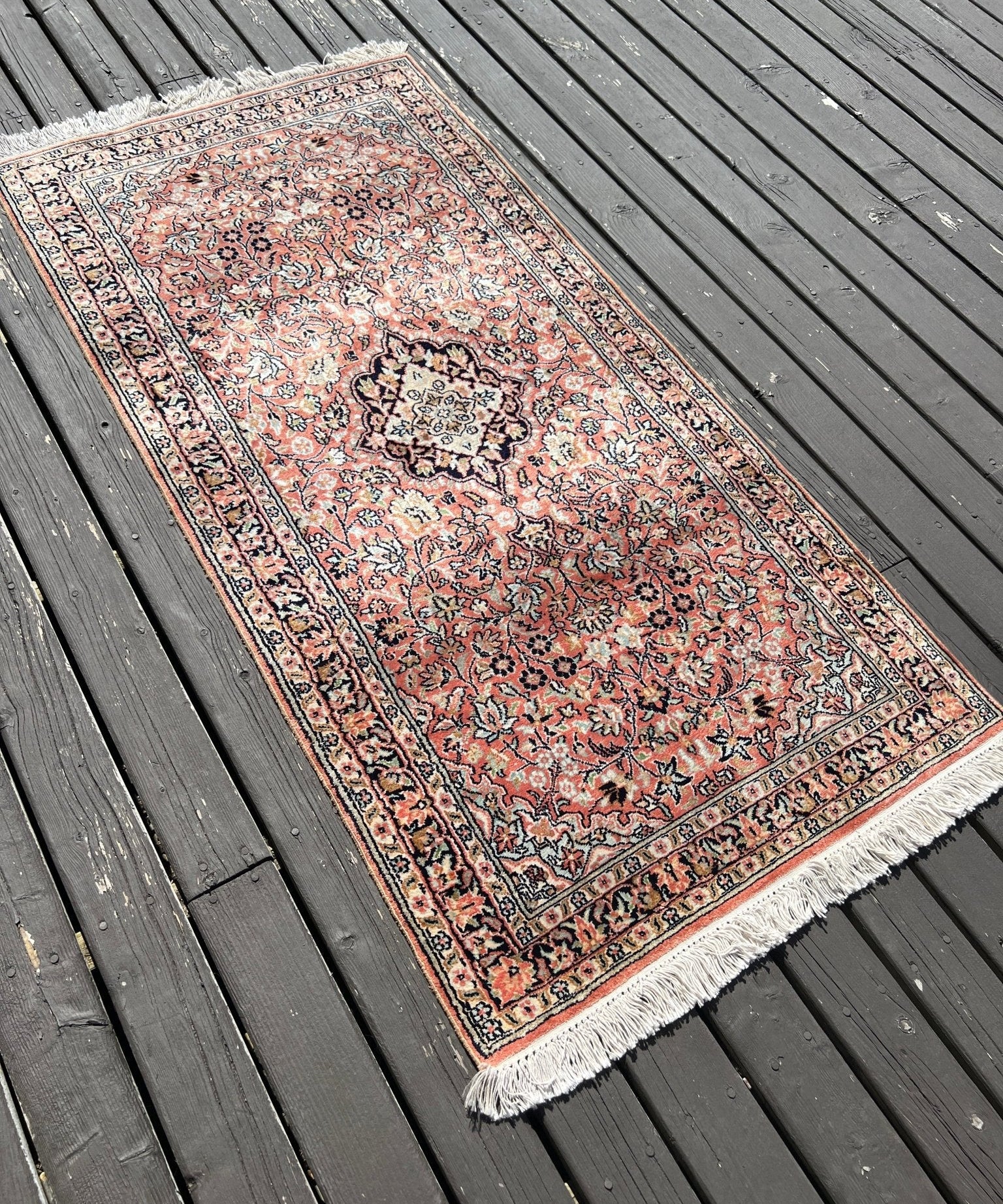 Red and cream Persian-style area rug with floral medallion pattern and short fringe
