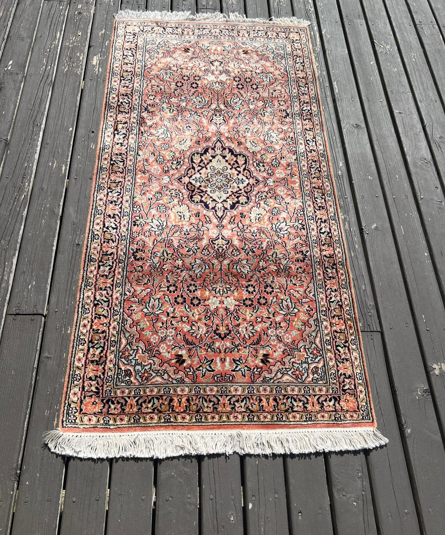 Red and cream Persian-style area rug with floral center medallion and fringe edges