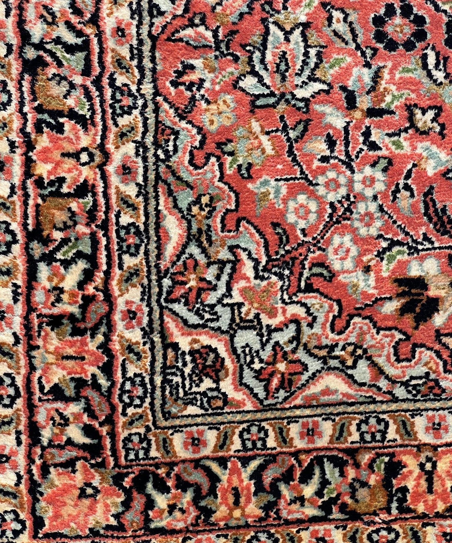 Close-up of red, cream, and black floral pattern on an area rug border