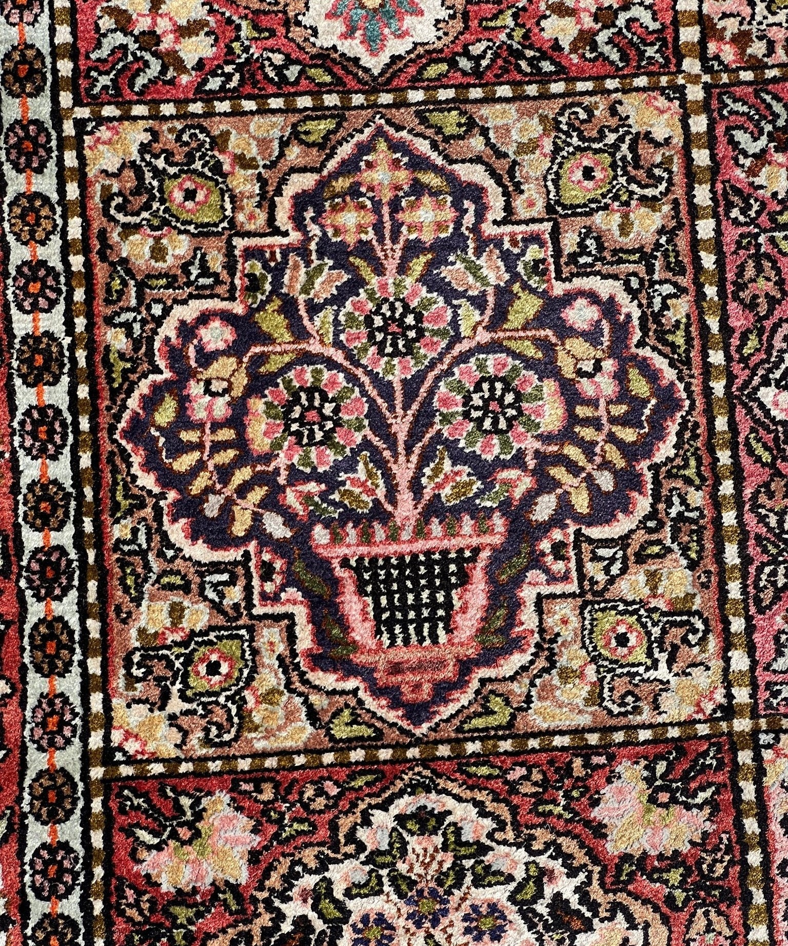 Rug center medallion close-up with dark red, cream, and multicolor floral details