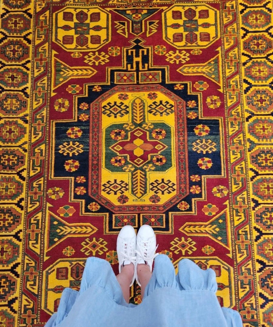 Kazak area rug full view with central medallion and geometric field in gold and red
