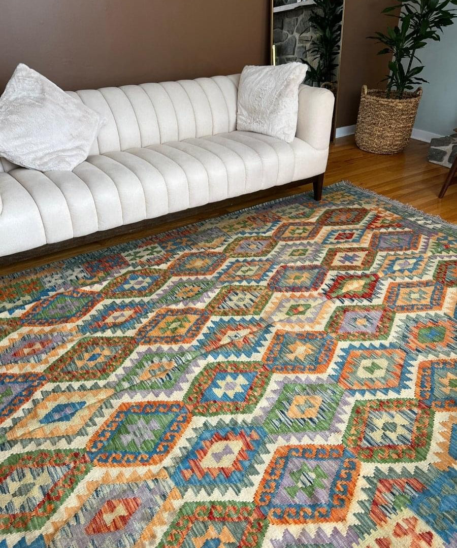 Geometric kilim rug with multicolor diamond pattern in orange, blue, and green.