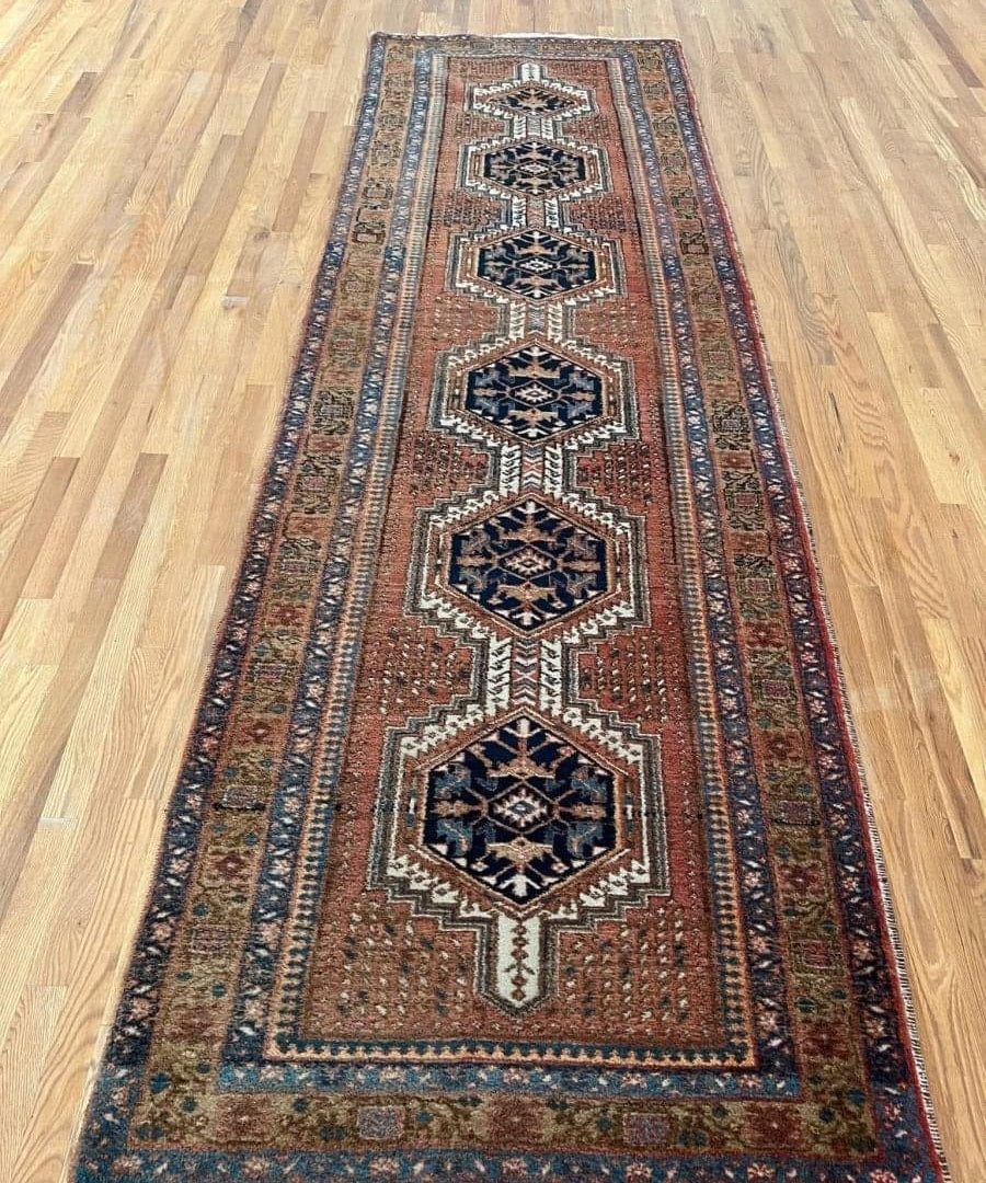 Runner rug in rust and navy with three stacked diamond medallion patterns