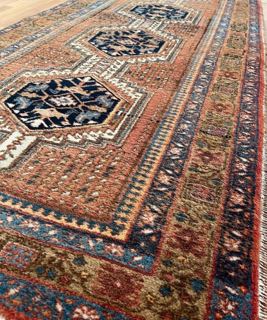 Runner rug detail with rust ground, navy motifs and ivory border lines