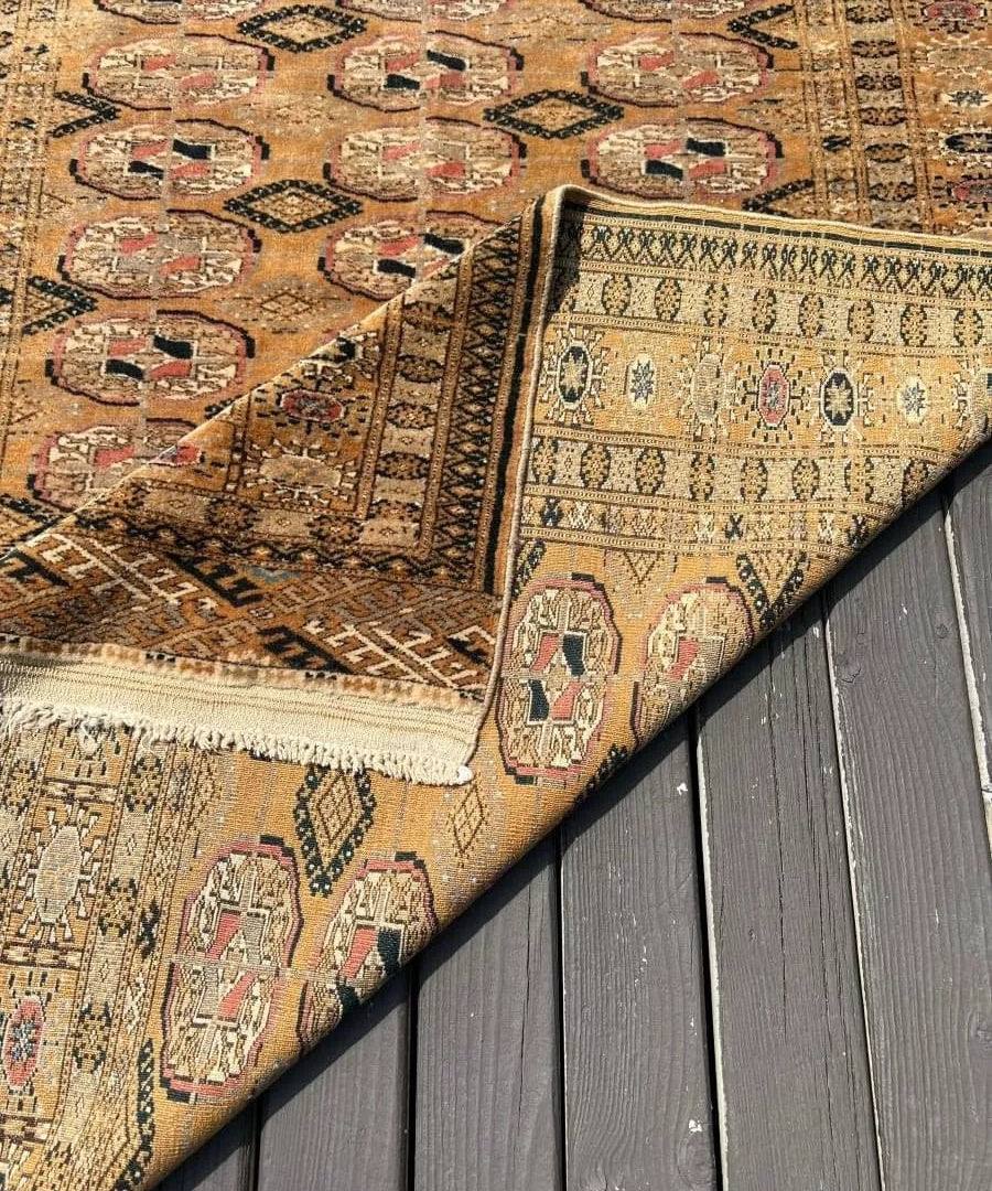Vintage Tekke rug corner with beige field, geometric motifs, dark border, fringe