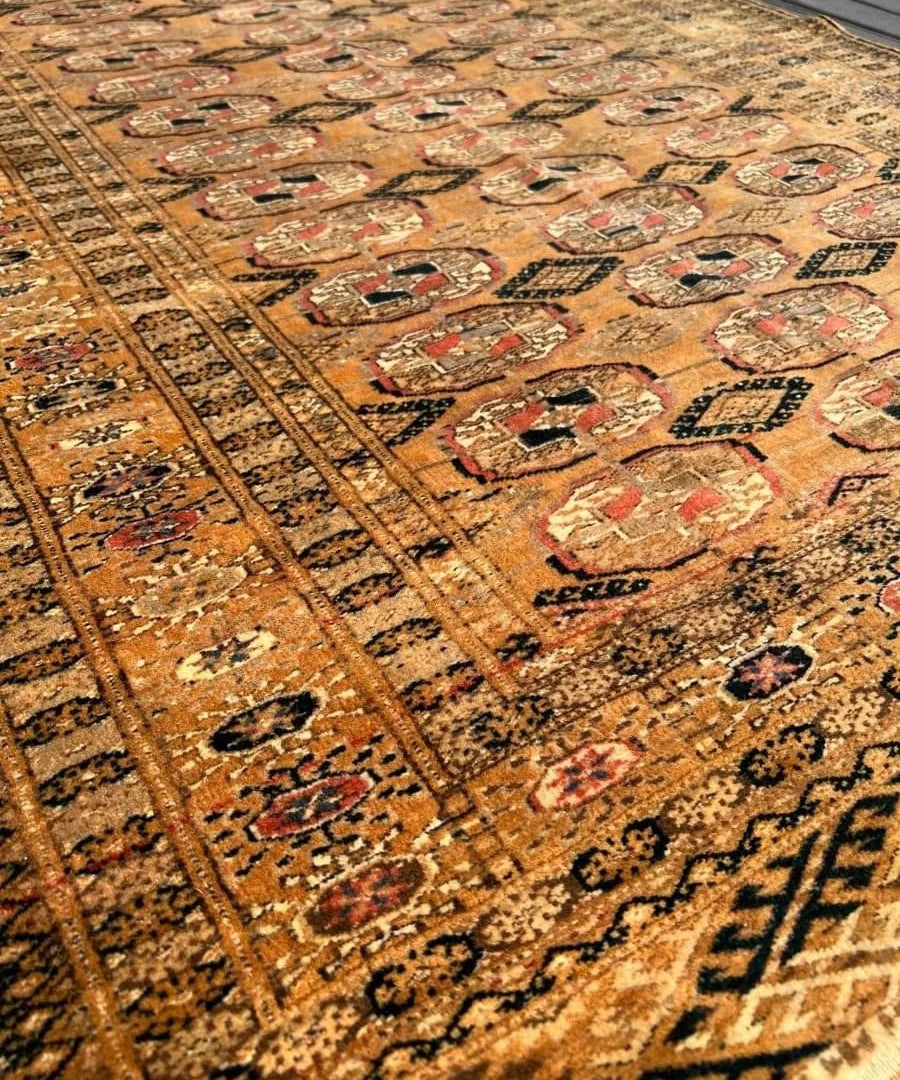 Vintage Tekke rug close-up, rust and cream medallion motifs with dark border