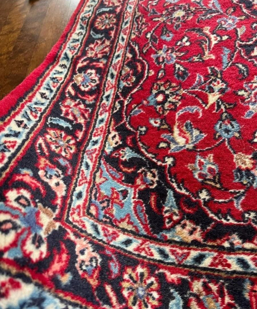 Persian Kashan runner rug, red with navy scrolling vines and cream border stripes.