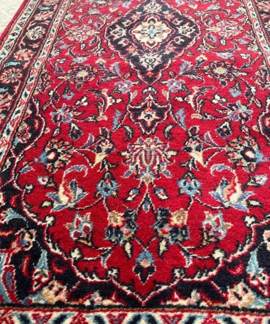 Persian Kashan runner rug, red ground with ornate navy and cream central medallion.
