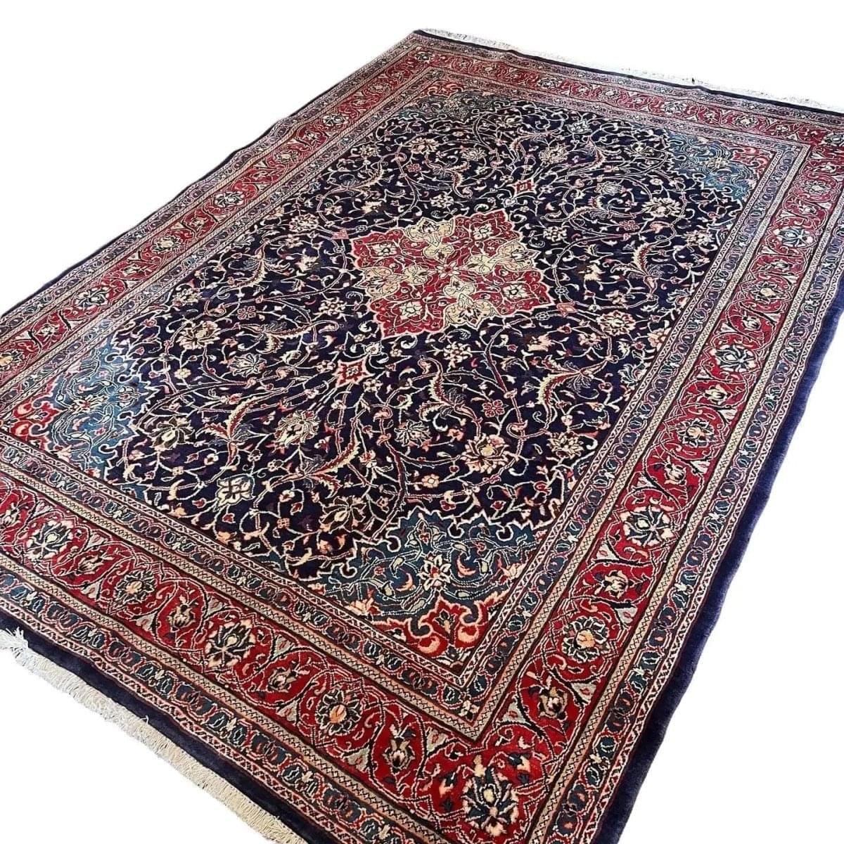 Persian arak rug with navy floral center medallion, red border, and blue highlights