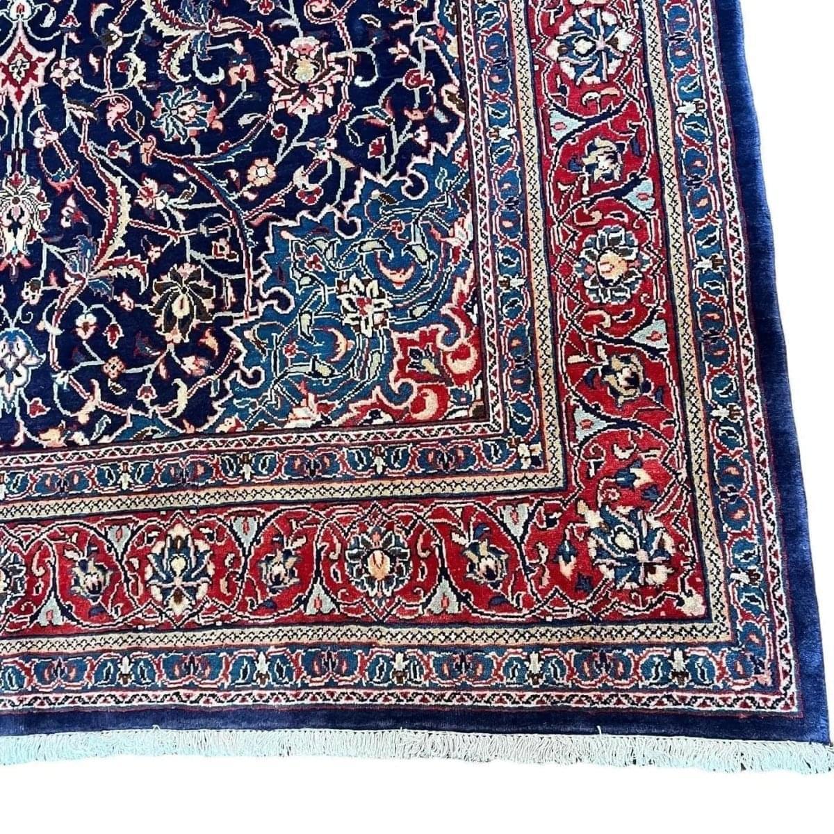 Persian arak rug corner with navy vines, red panels, and light blue border strip
