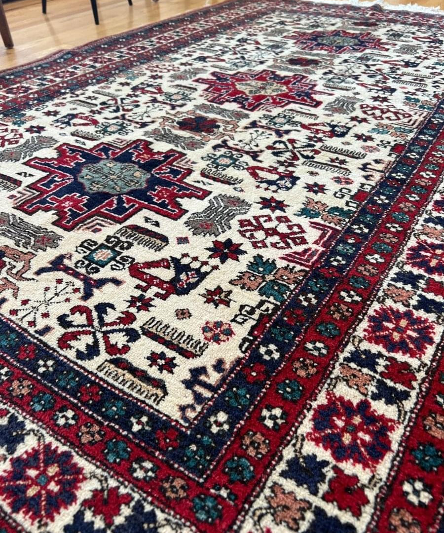 Geometric Persian rug with ivory background, red navy border, star and cross motifs