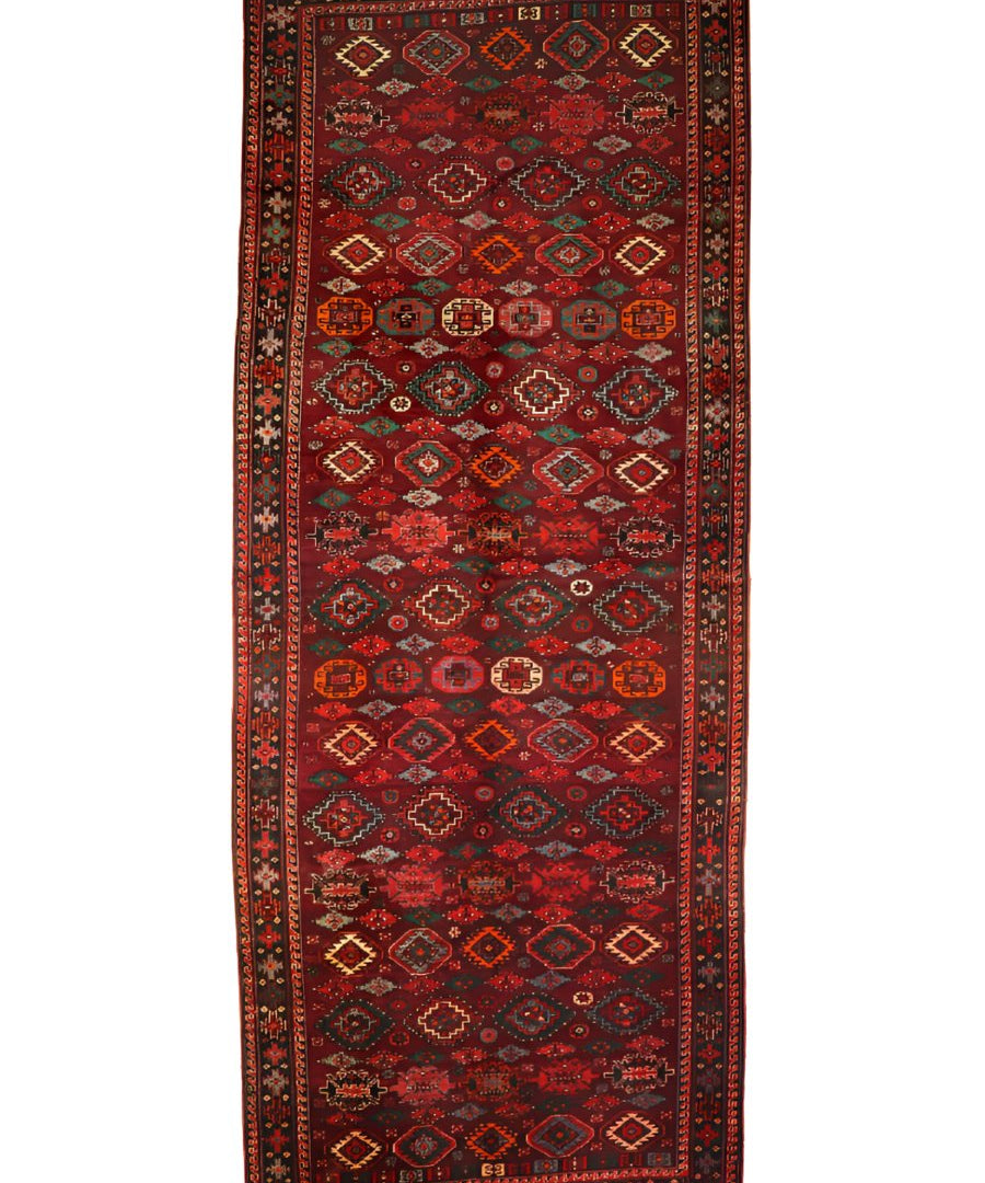 Persian Quchan rug with dark red border and teal diamond motif lattice on a muted field