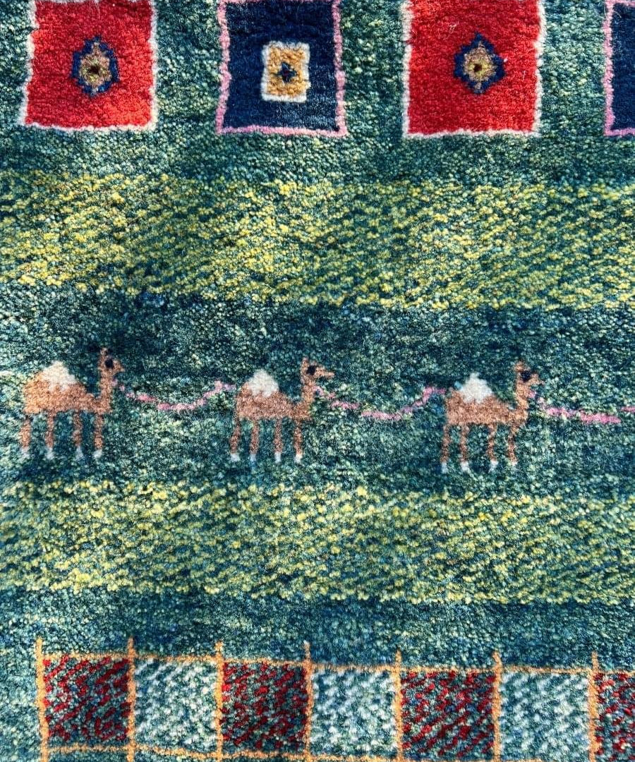 Gabbeh rug with red and blue medallions on teal green ground, geometric border