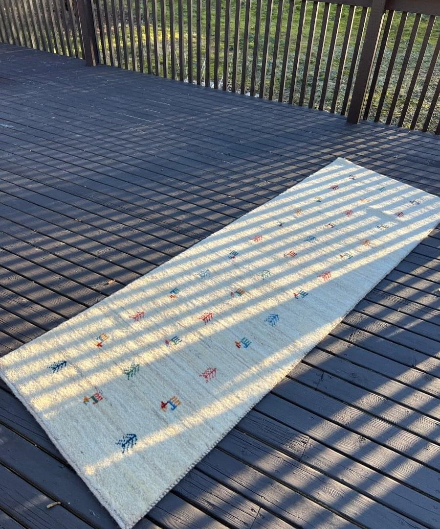 Persian Gabbeh-style runner with light blue field and small multicolor animal motifs
