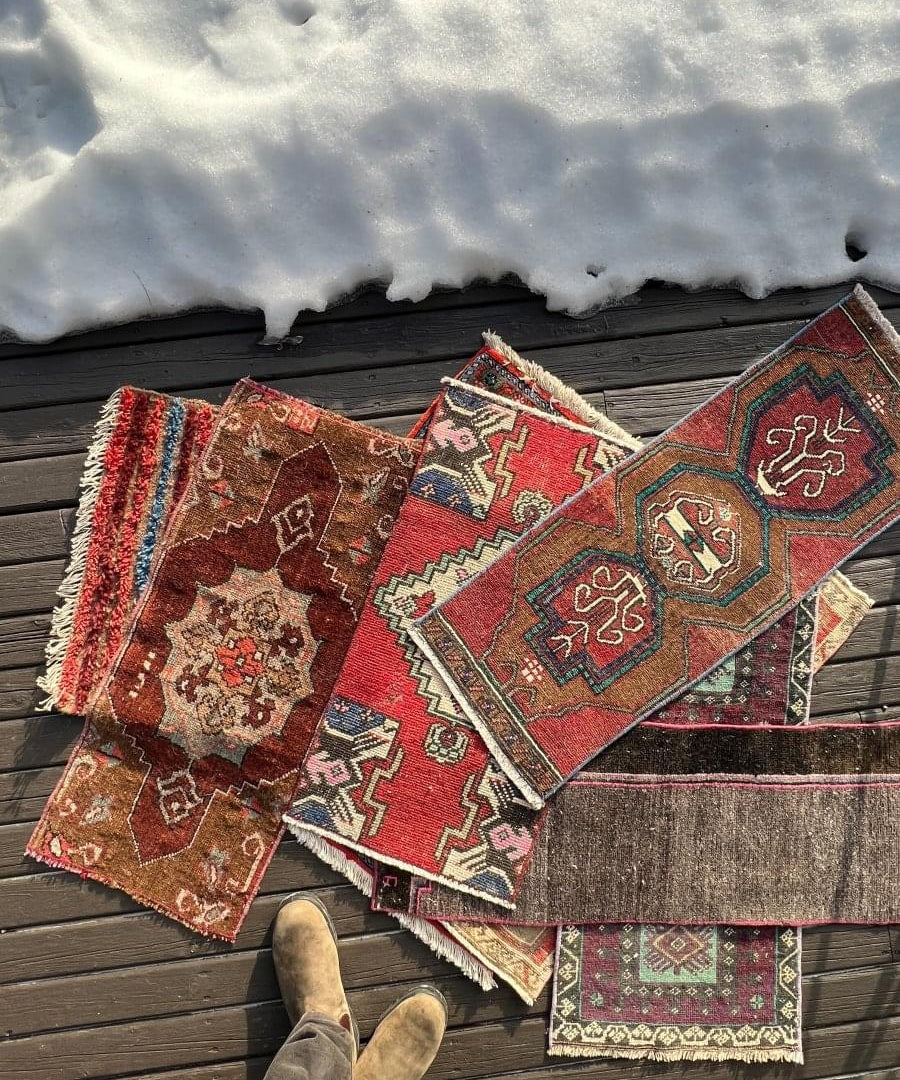 Mini rug with red, teal, and beige geometric motifs, cream border and fringed edge