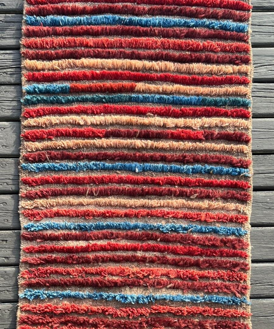 Mini rug with red and blue striped pile, beige edging and short fringes