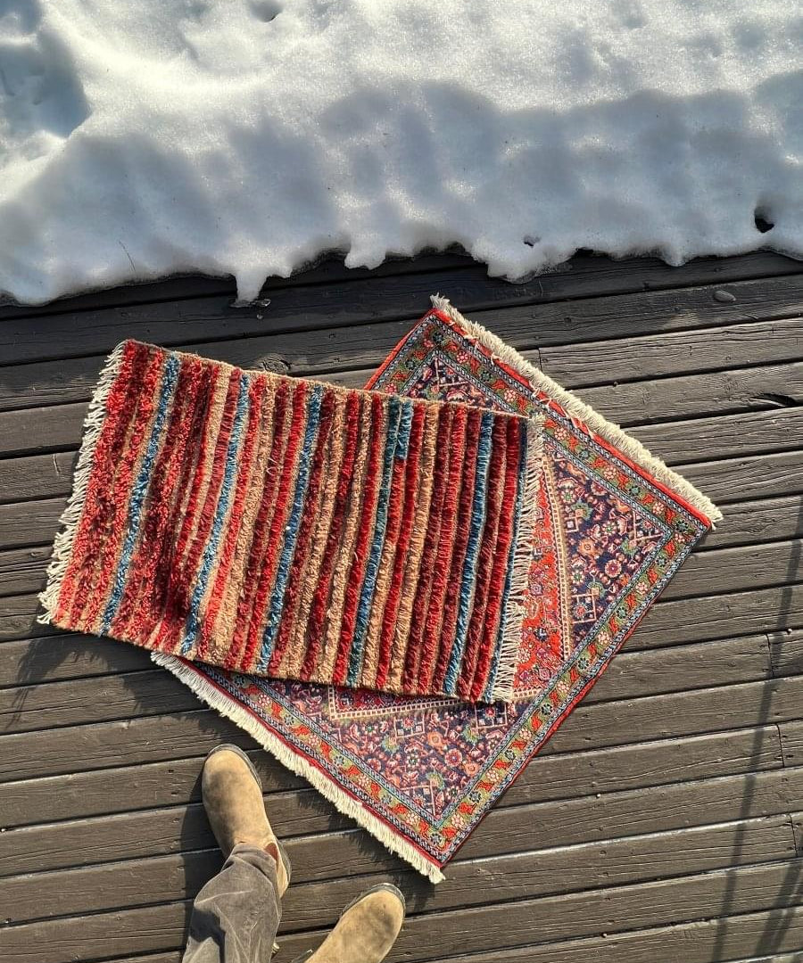 Mini rug with red field and ornate blue-and-cream border, layered edges and fringe
