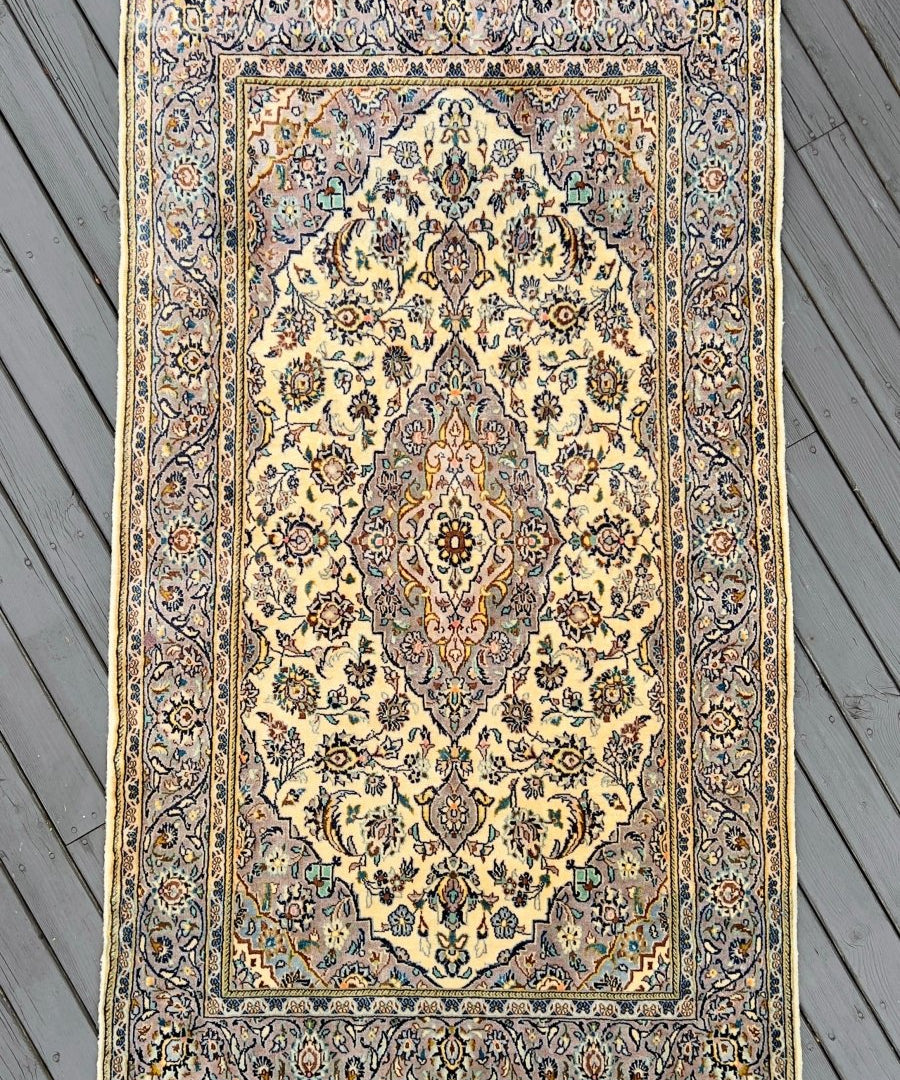 Persian Kashan rug with light cream field, blue border, central medallion