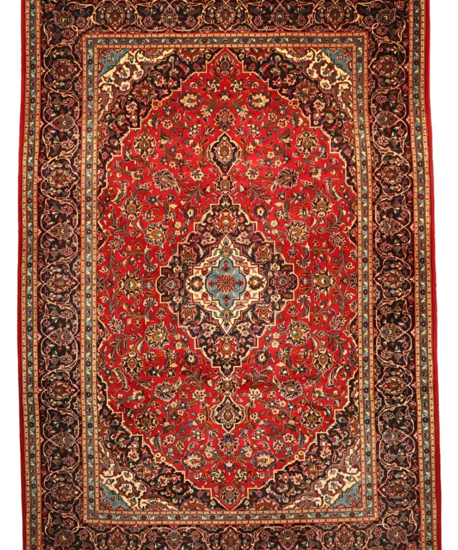 Persian Kashan rug with red field, central medallion, navy and cream ornate border