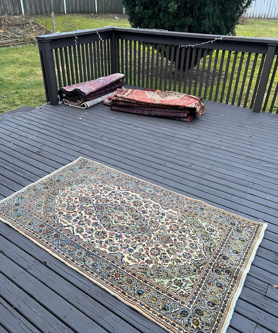Persian Kashan rug, cream and teal floral pattern with dark blue edging, rectangular layout