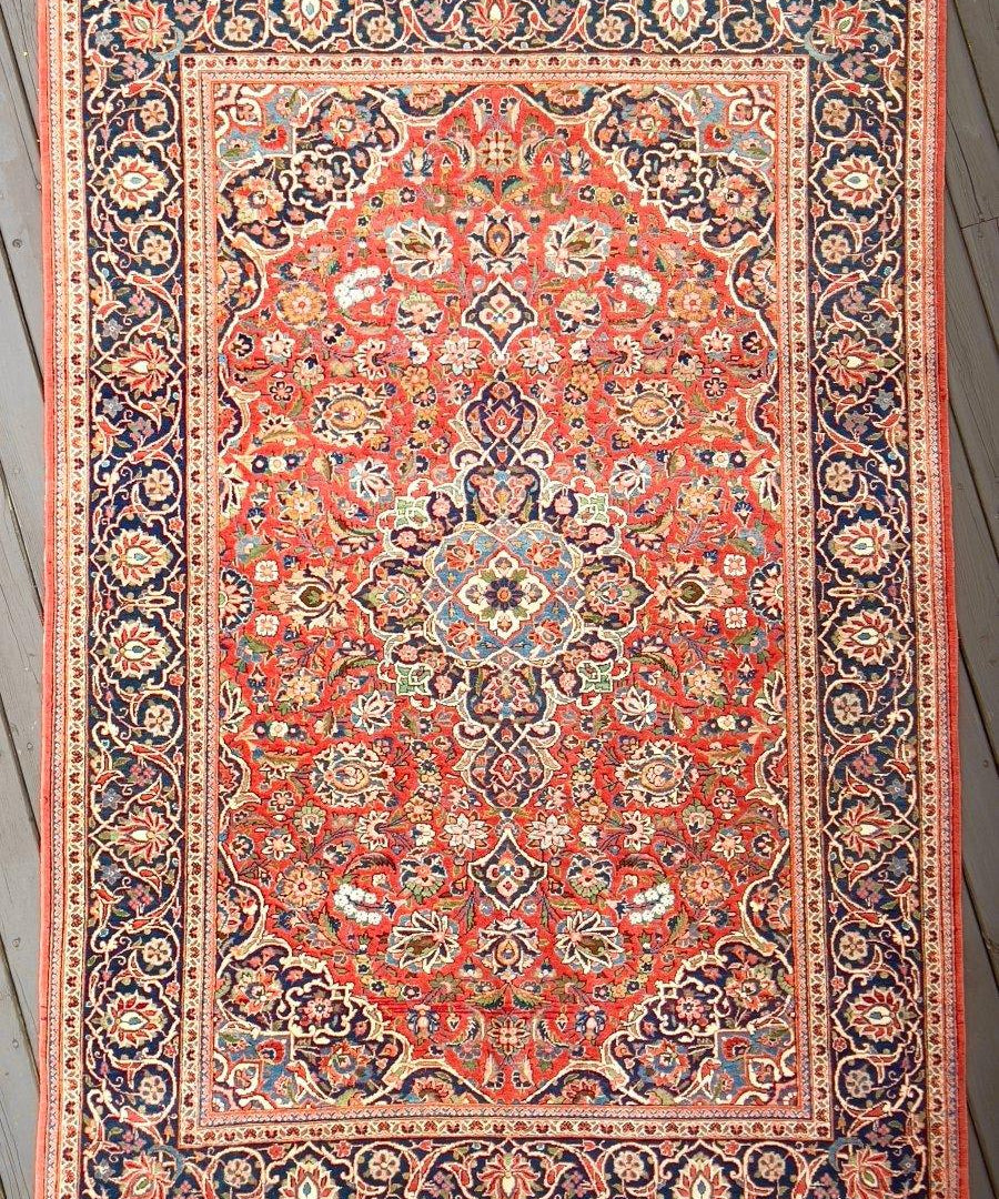 Kashan rug with red center medallion and ornate navy border