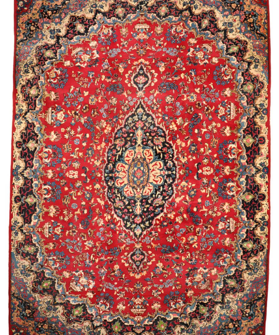 Red ornamental rug with central medallion, navy and ivory floral border, fringeless edges