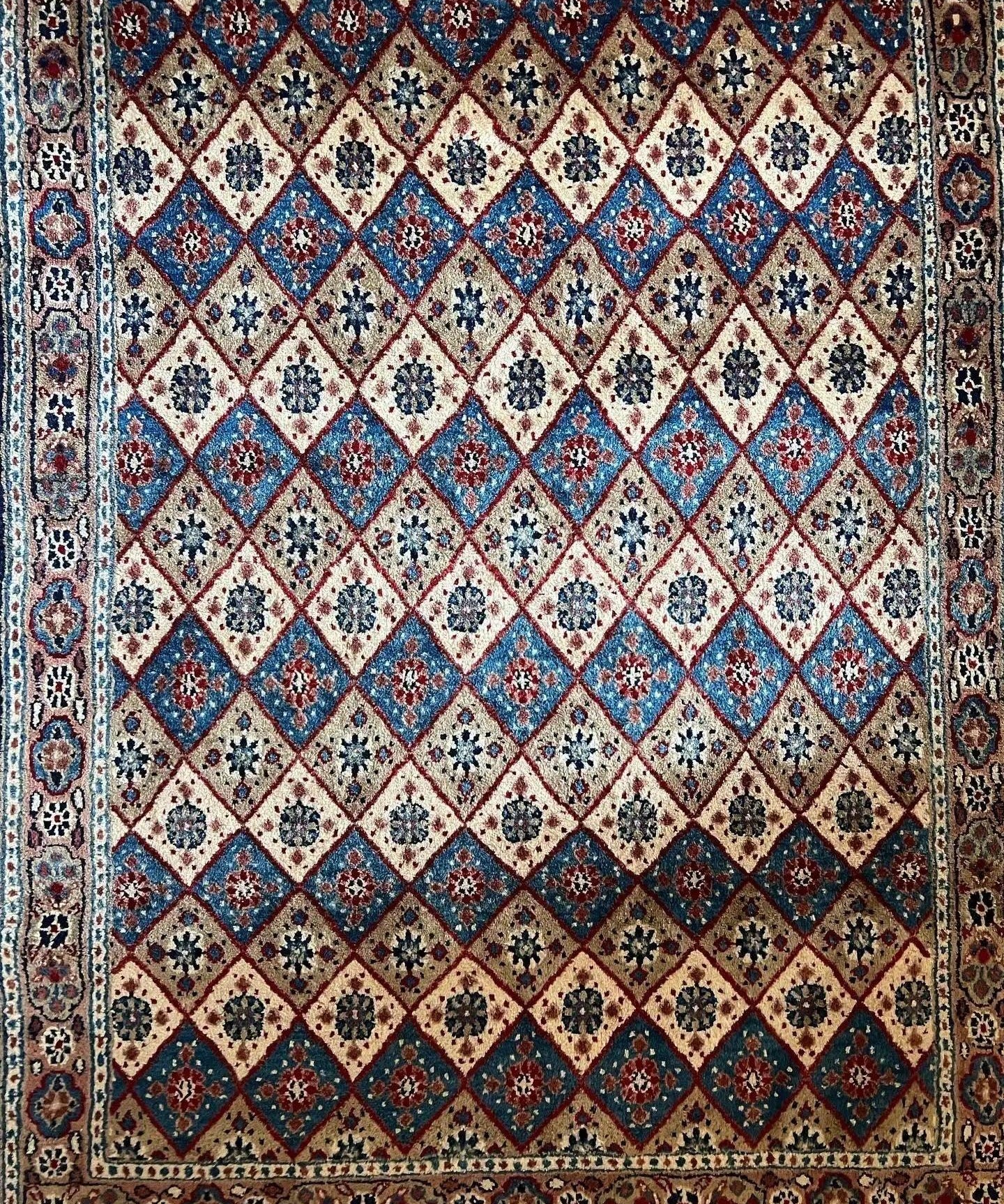 Persian-style runner rug with red, blue, cream diamond pattern and decorative border