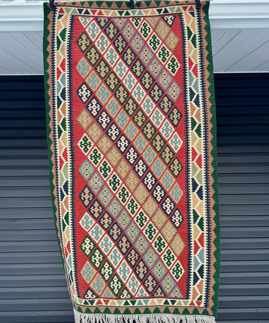 Persian Qashqai kilim rug, multicolor geometric diamonds with green border and fringe