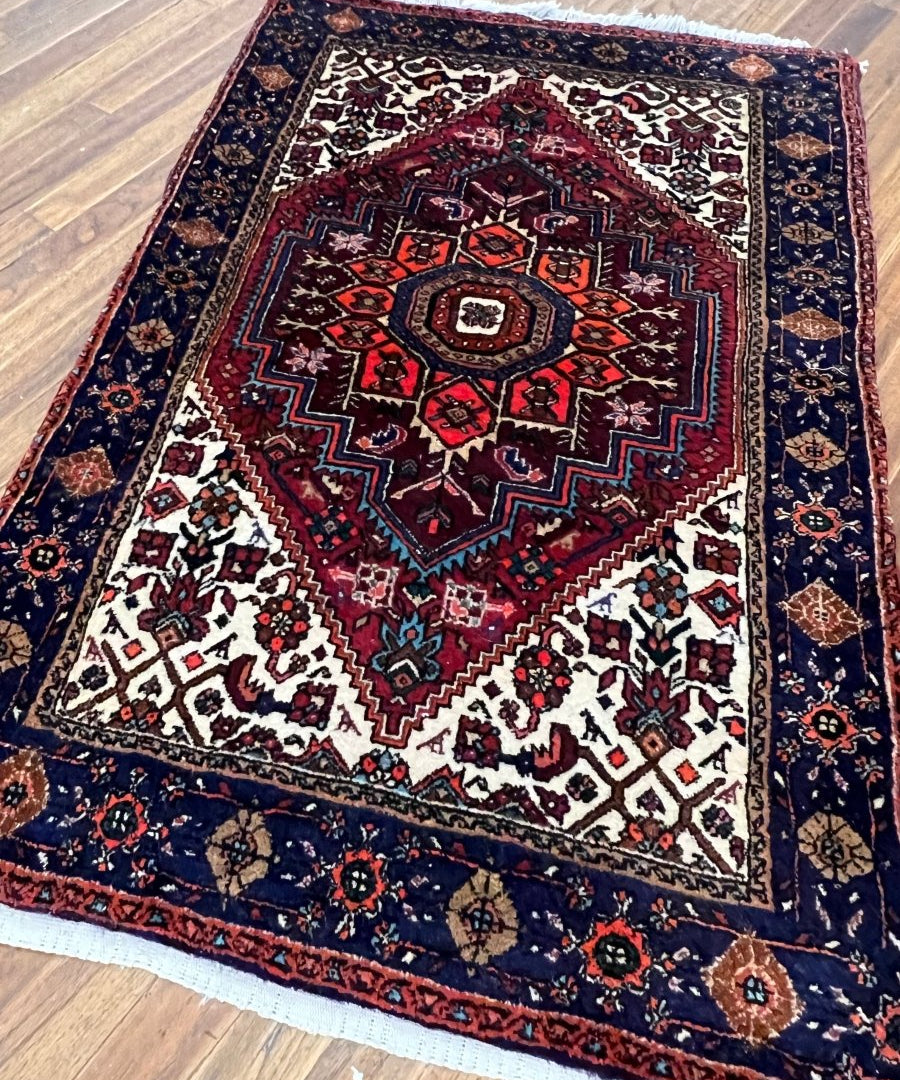 Rug with red-and-navy central medallion, white diamond accents, full view