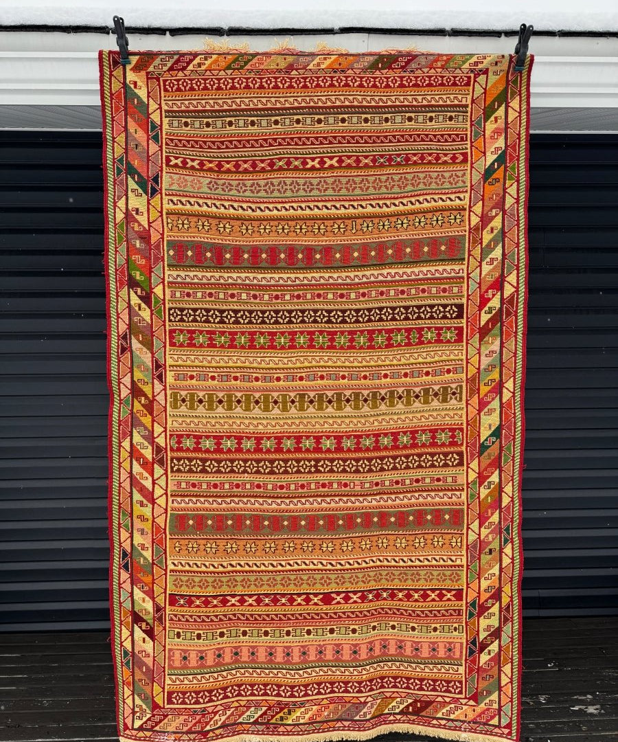 Persian kilim rug with red, beige, and green geometric border and striped bands