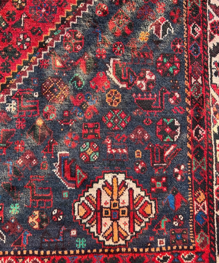Persian Shiraz rug detail close-up with central rosette and red, blue, green accents