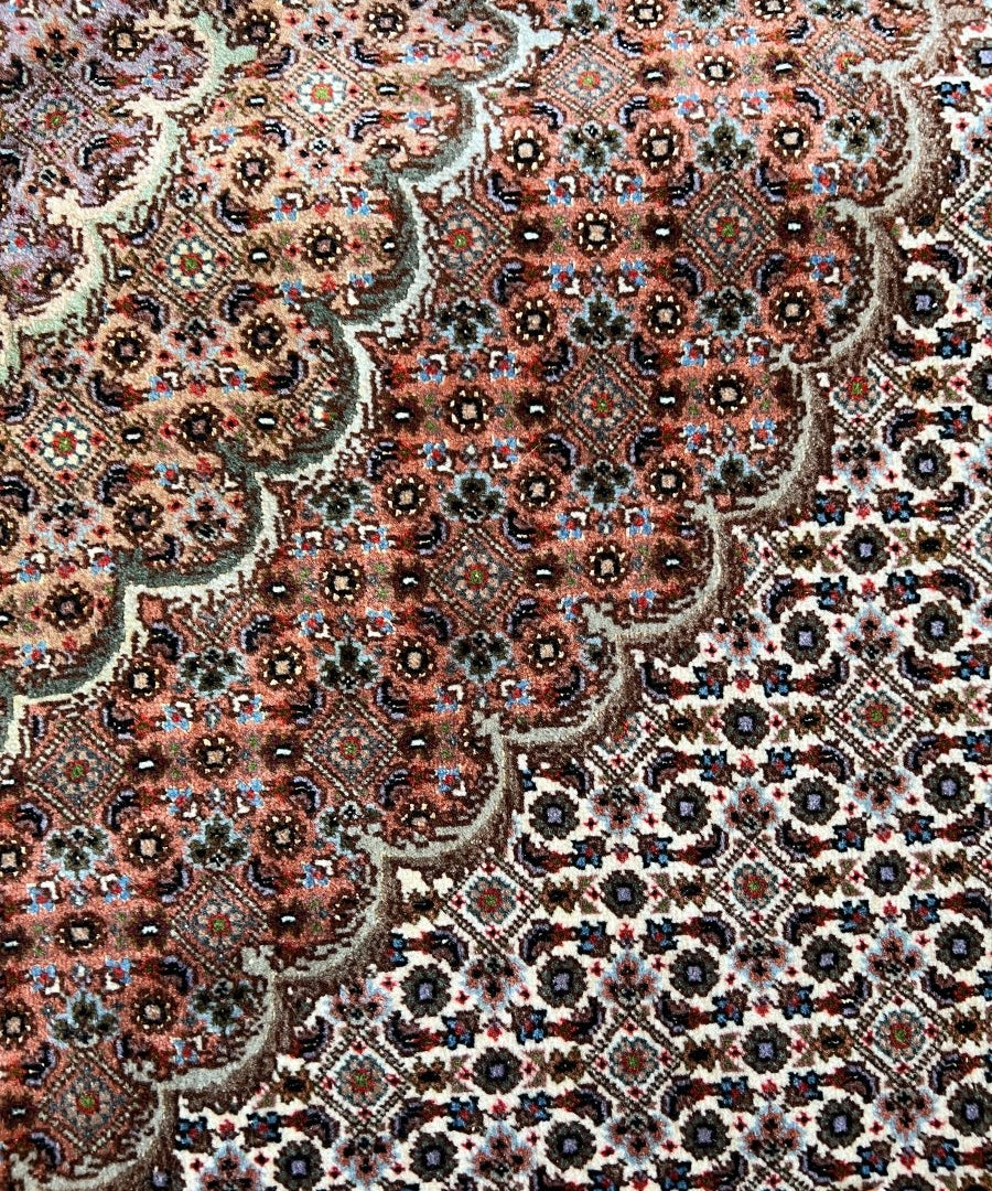 Persian Tabriz rug pattern close-up with rust red, teal, cream and floral medallion motifs