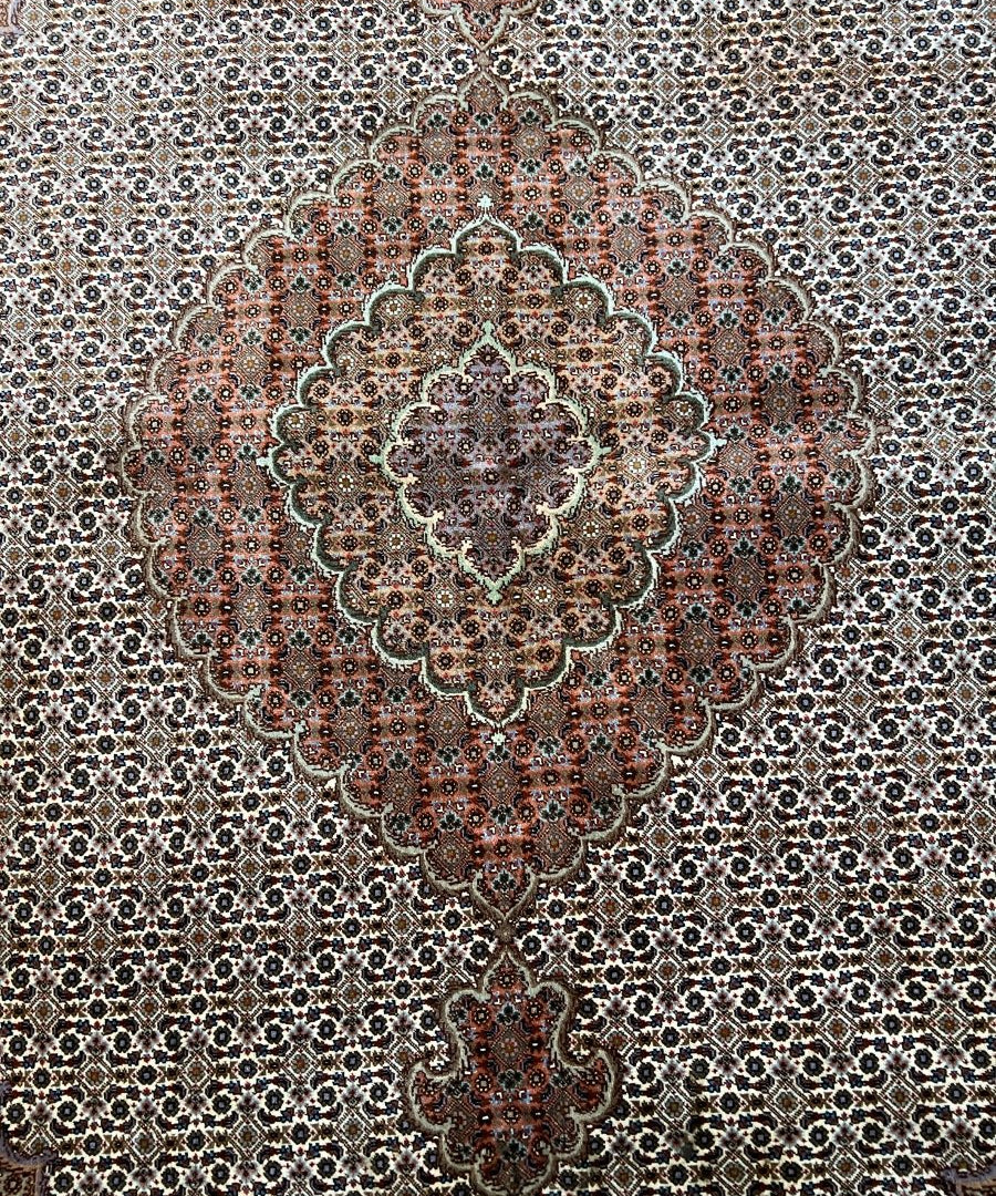 Persian Tabriz rug close-up of central medallion with cream, rust red, and dark blue details