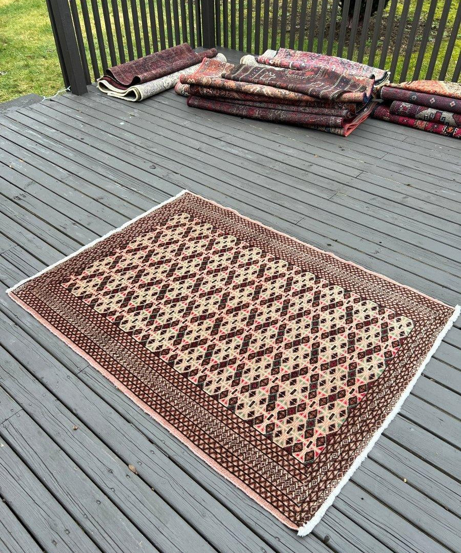 Persian Turkmen rug with geometric medallion pattern, brown and cream on dark border