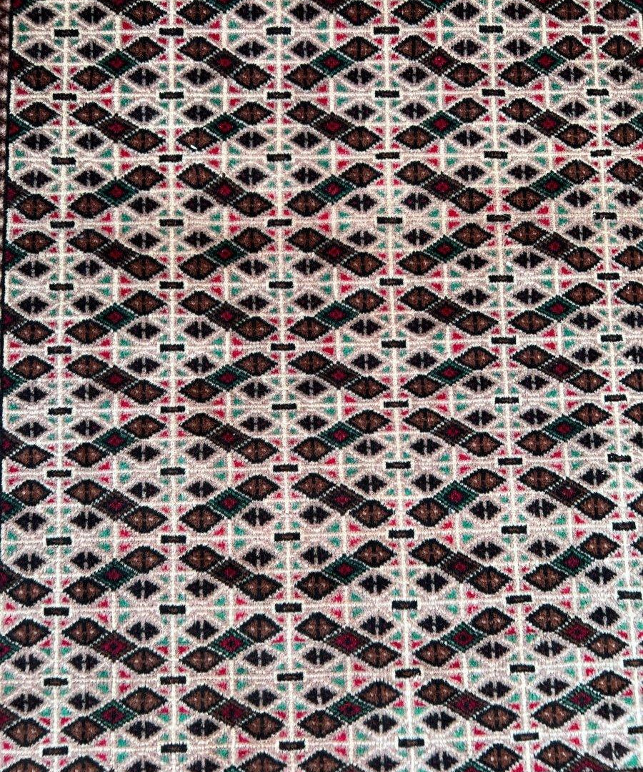 Persian Turkmen rug close-up, black ground with white cross and multicolor geometric motifs