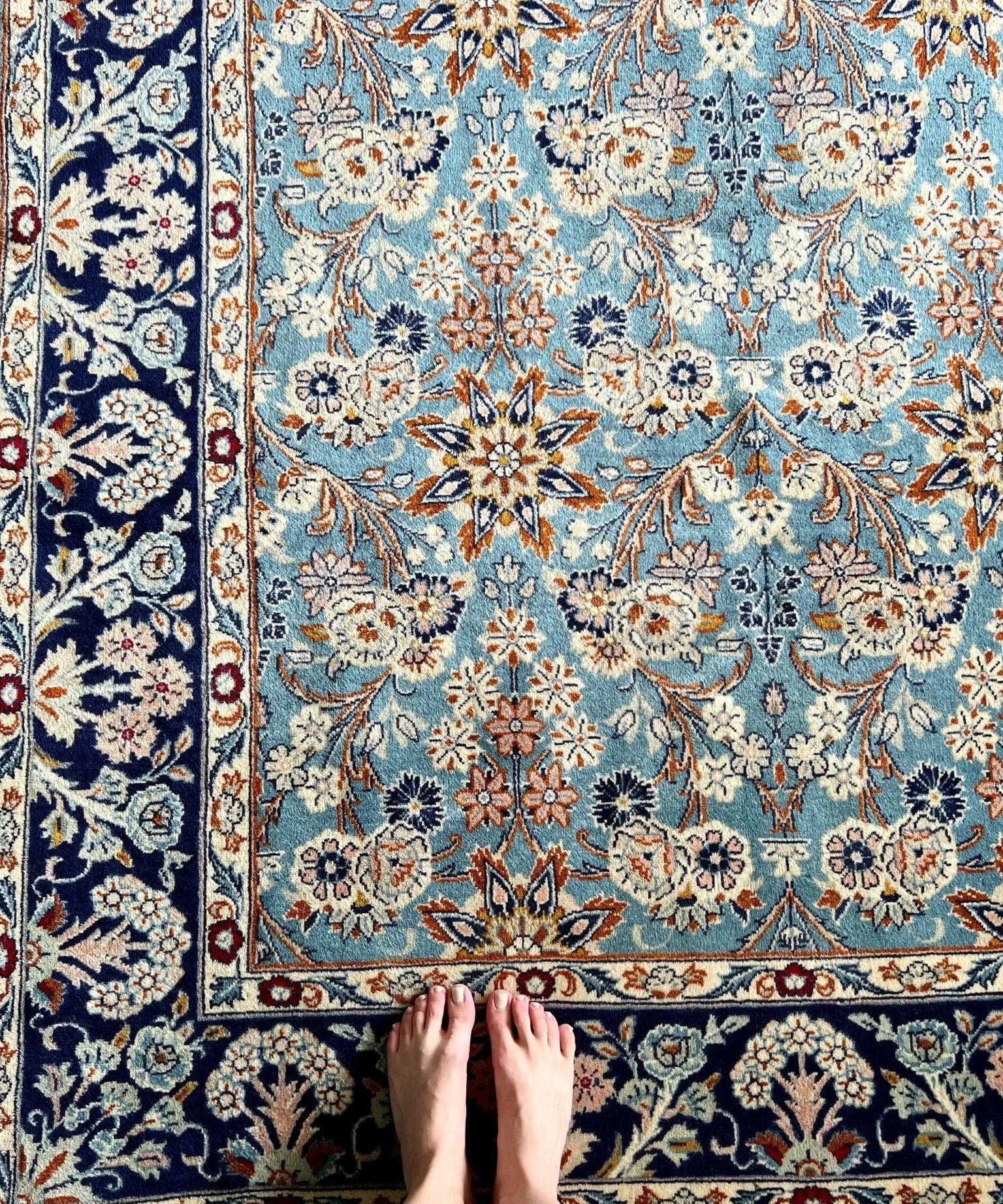 Floral Persian Yazd rug with light blue field, navy border, and ivory medallions