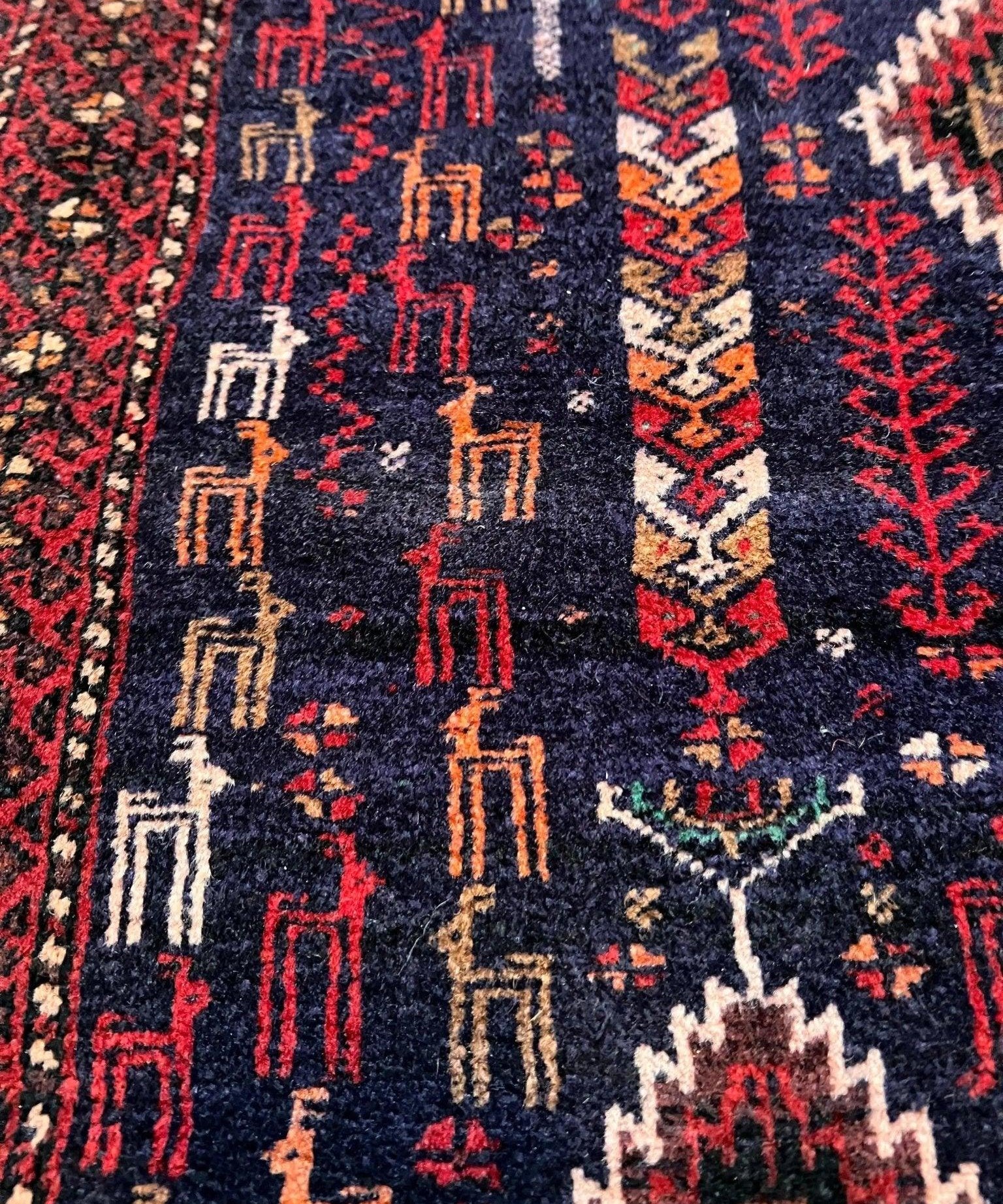 Close-up of rug pattern with navy ground, red and ivory geometric lines