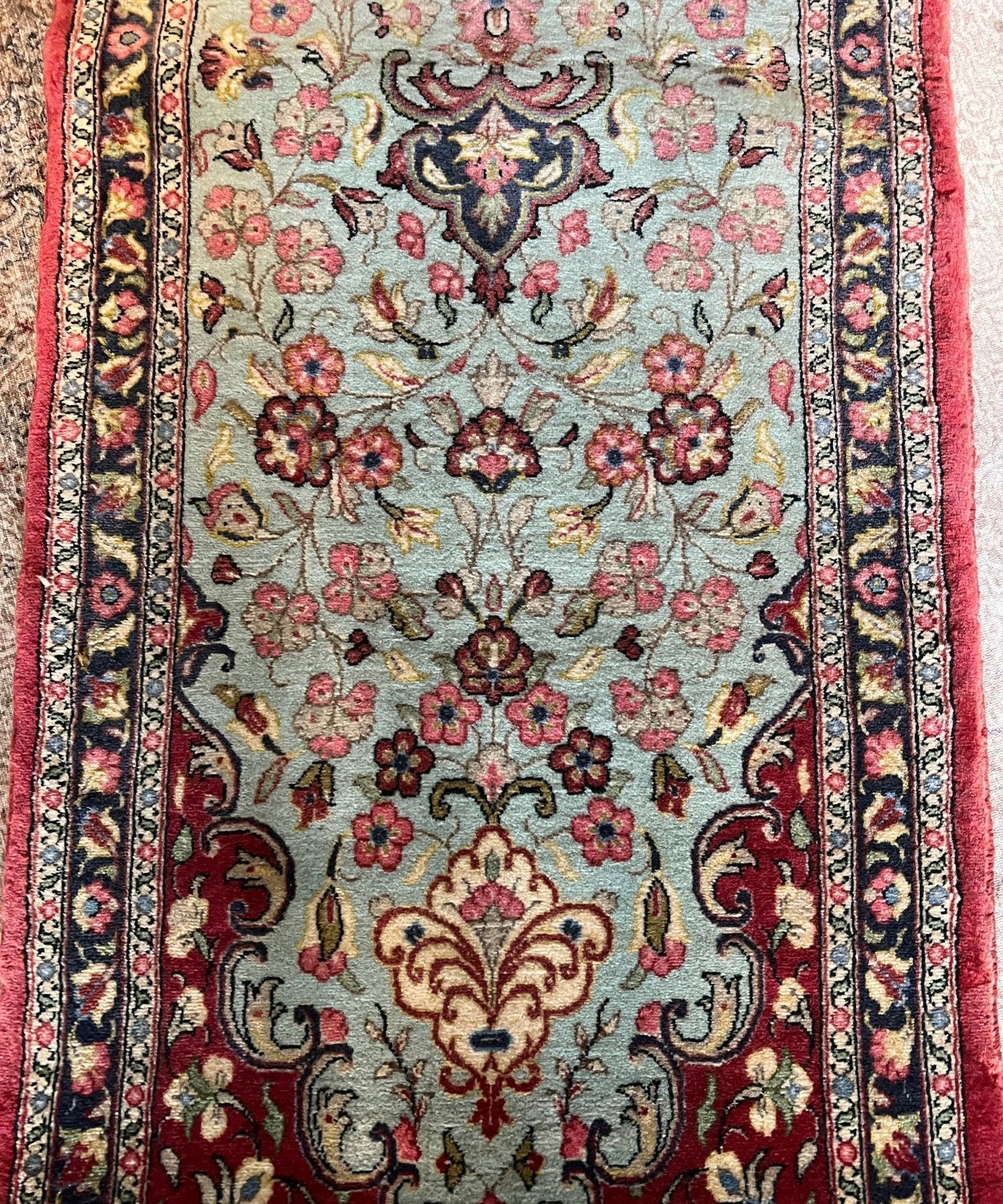 Persian Qom runner rug with central floral panel and decorative corners, light blue