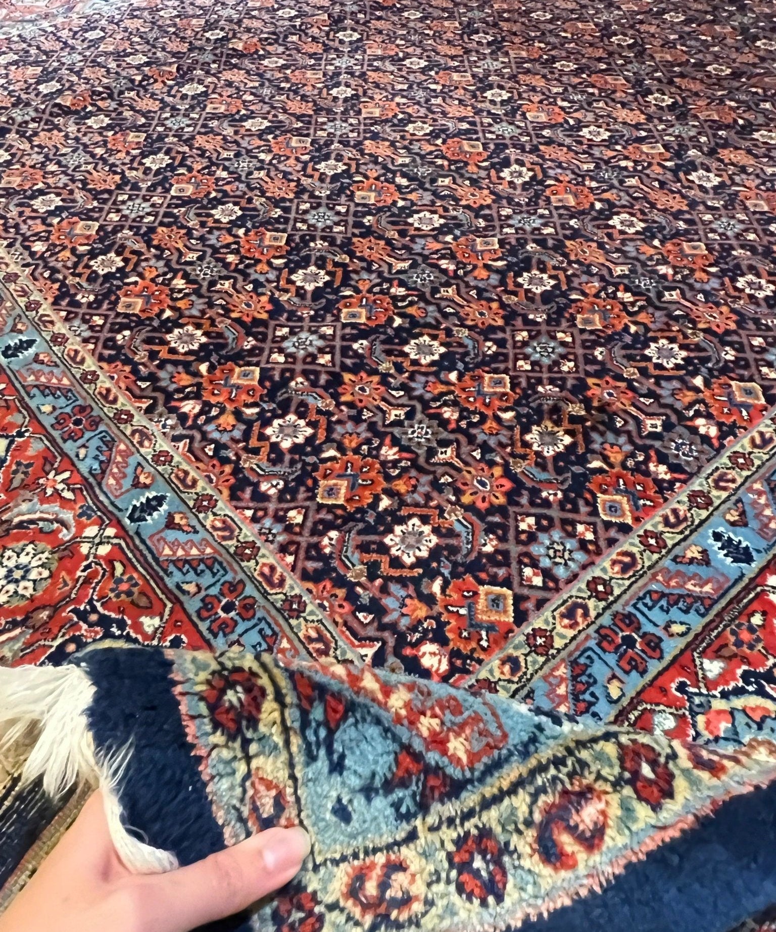 Persian Sarouk rug corner with multicolor medallions and decorative navy border