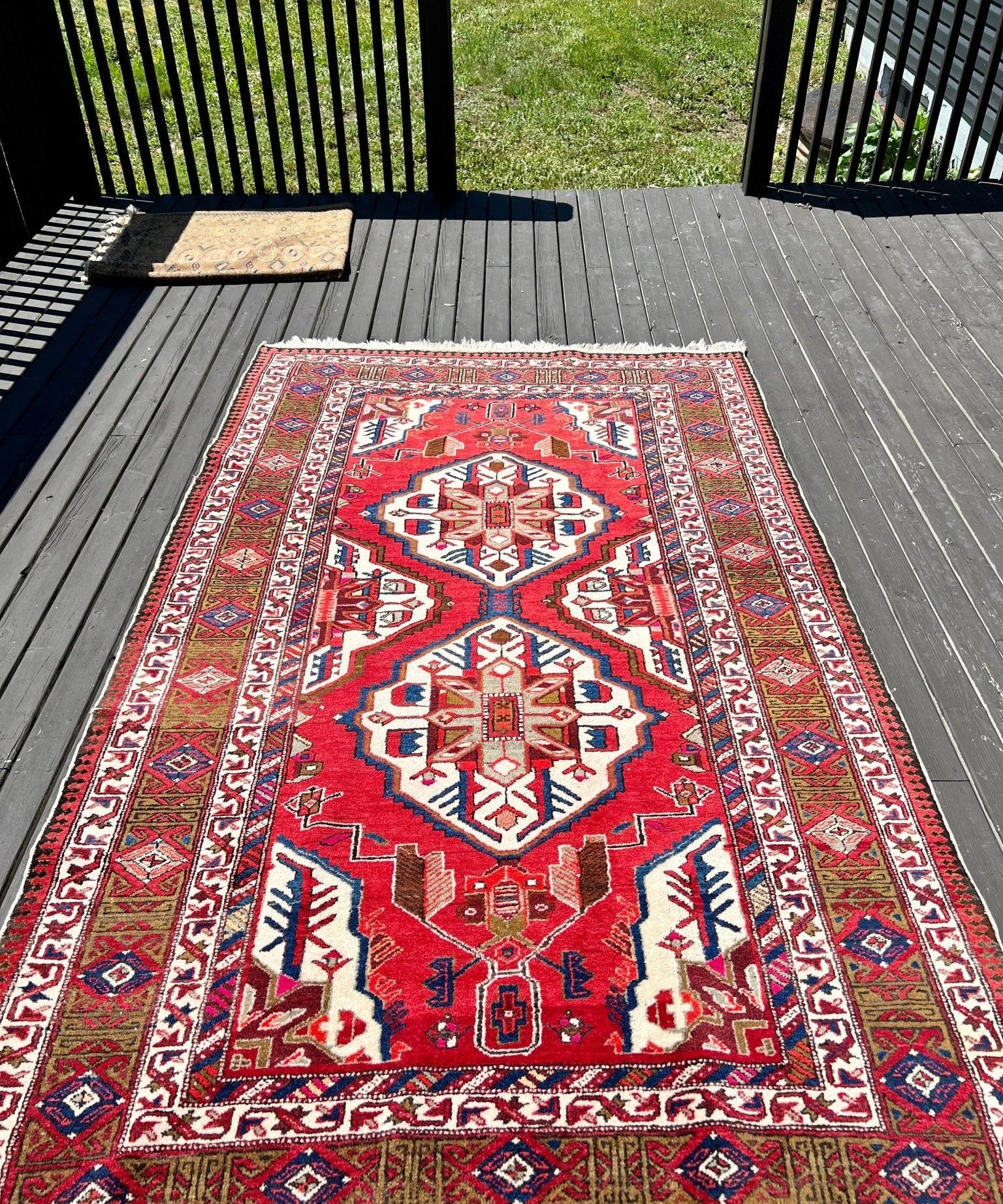 Vintage Persian Meshkin rug with red field and geometric medallion pattern, fringed border