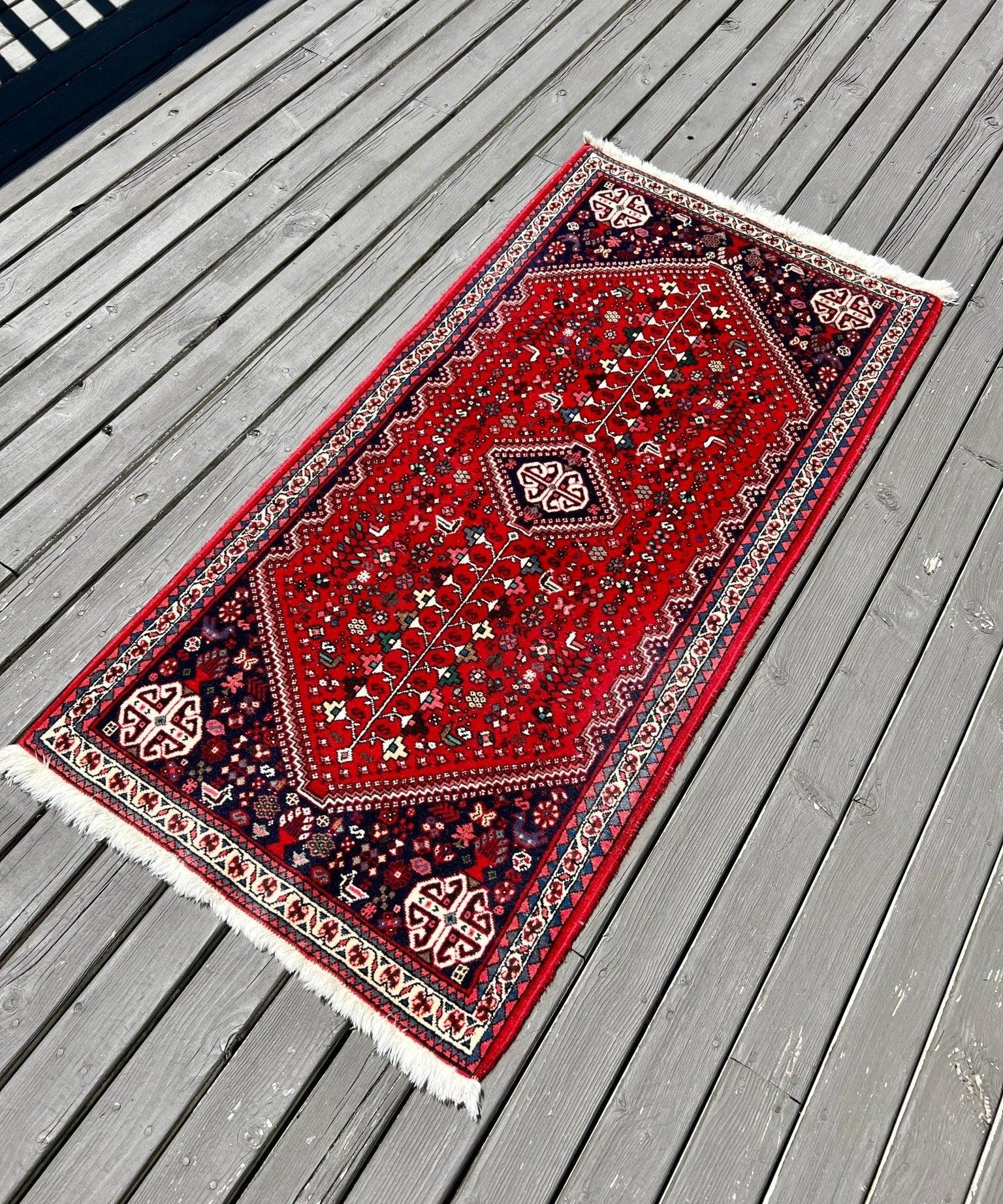 Persian Abadeh rug in red with central medallion and blue navy corner motifs