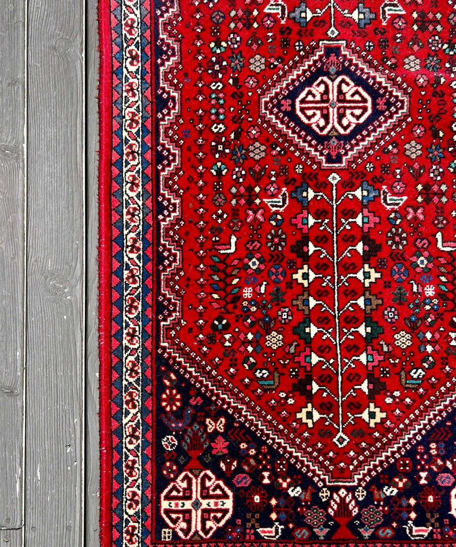 Persian Abadeh rug with red field and patterned blue, cream and navy border