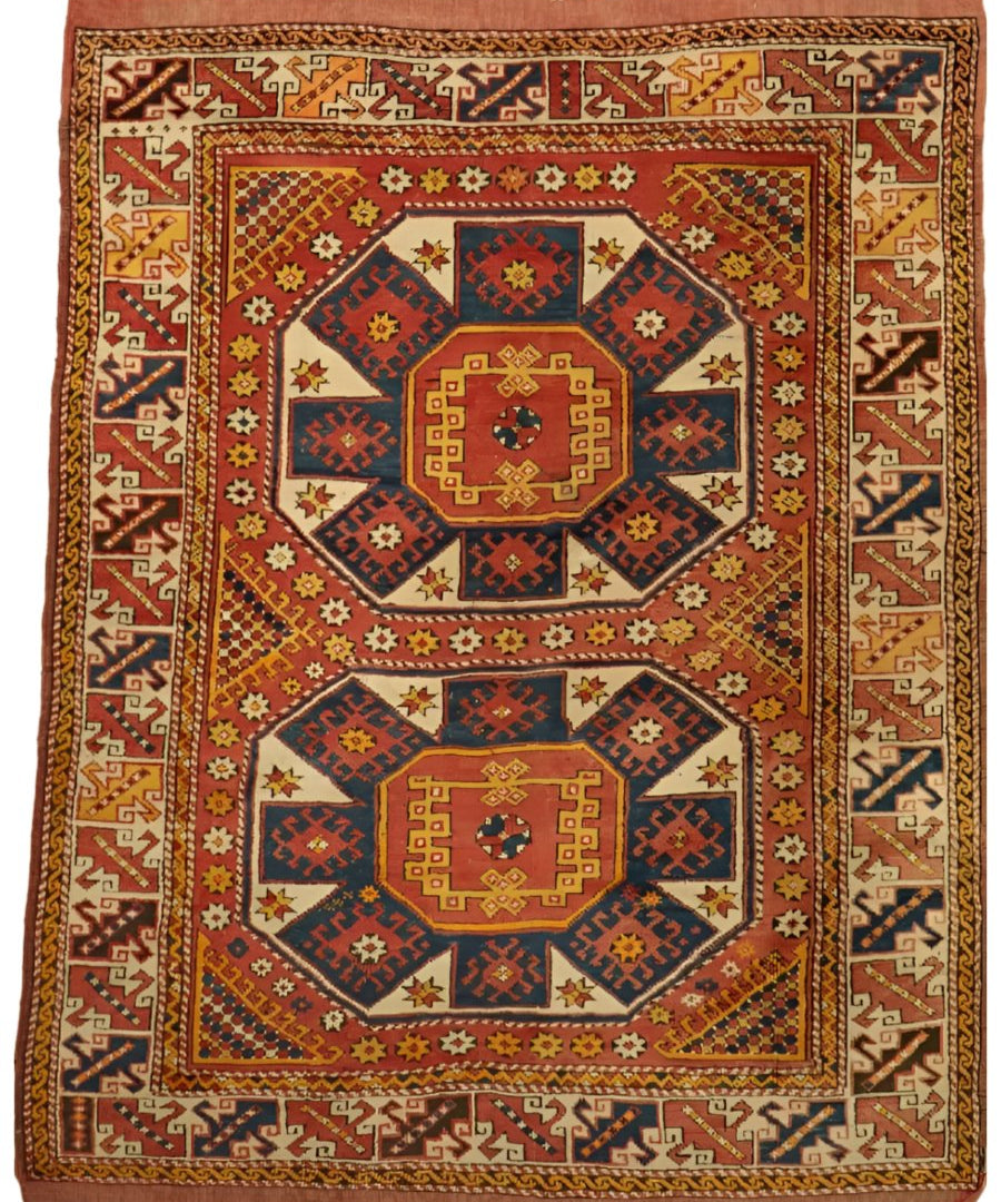 Decorative rug with red outer border and central square medallions in blue, gold, and cream.