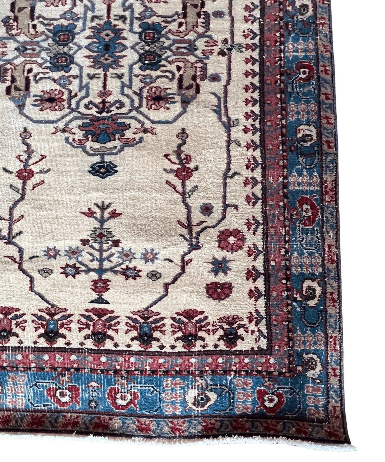 Turkish Isparta rug detail: cream panel with blue border and red floral lattice trim